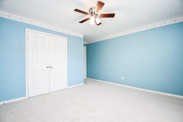 unfurnished bedroom featuring ceiling fan, a closet, and carpet floors