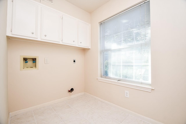 washroom featuring washer hookup, electric dryer hookup, light tile patterned flooring, and cabinets