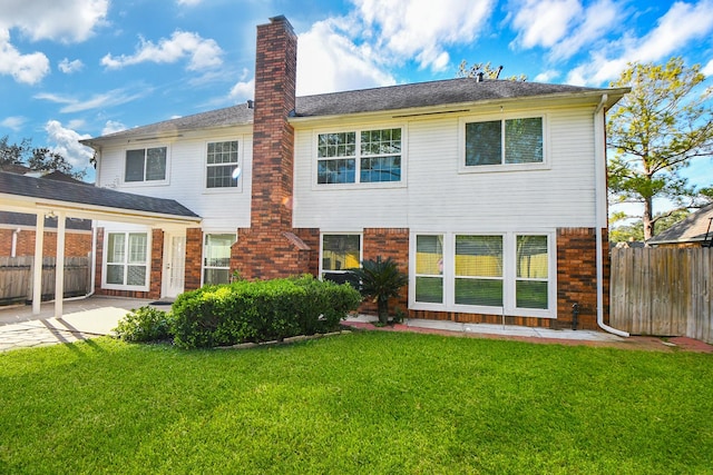 rear view of property featuring a patio area and a yard