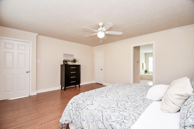 bedroom with crown molding, ensuite bath, hardwood / wood-style flooring, ceiling fan, and a textured ceiling