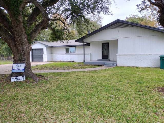 ranch-style house featuring a garage and a front lawn