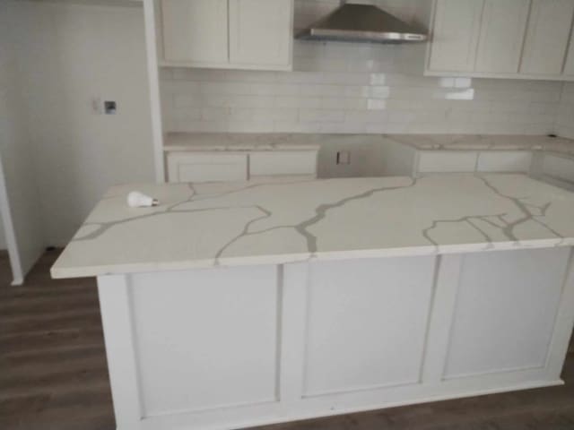 kitchen featuring white cabinets, dark hardwood / wood-style flooring, light stone counters, and backsplash