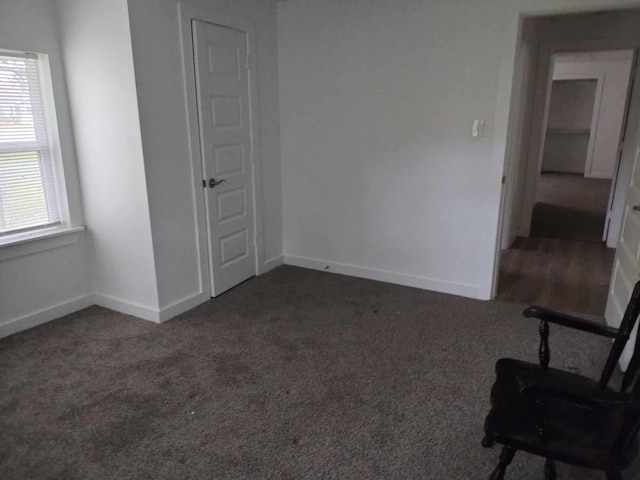 unfurnished room featuring dark carpet