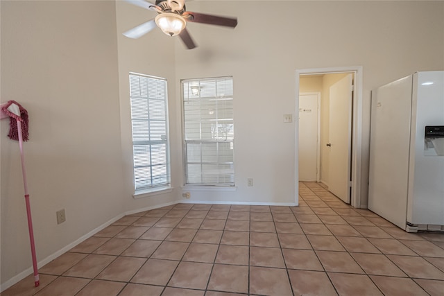 tiled spare room featuring ceiling fan