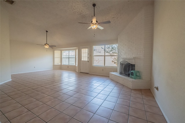 unfurnished living room with a textured ceiling, vaulted ceiling, ceiling fan, light tile patterned floors, and a fireplace