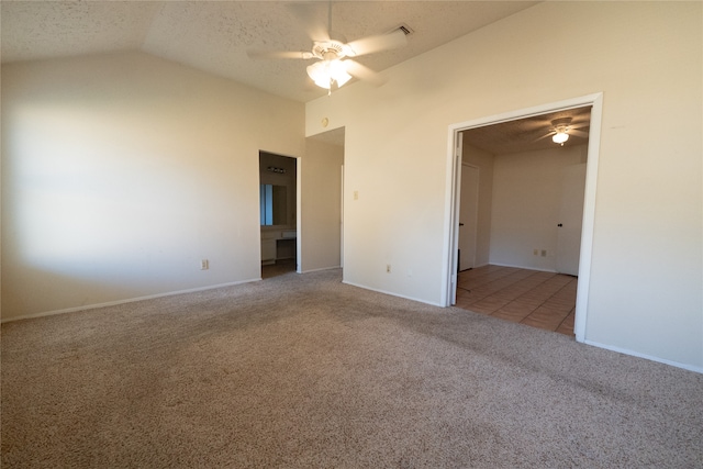 unfurnished room featuring a textured ceiling, light carpet, ceiling fan, and vaulted ceiling