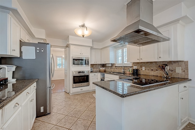 kitchen featuring white cabinets, appliances with stainless steel finishes, backsplash, and ventilation hood