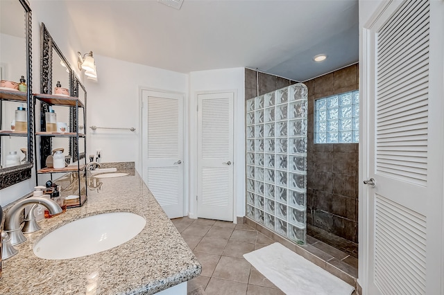 bathroom with tile patterned floors, vanity, and a tile shower