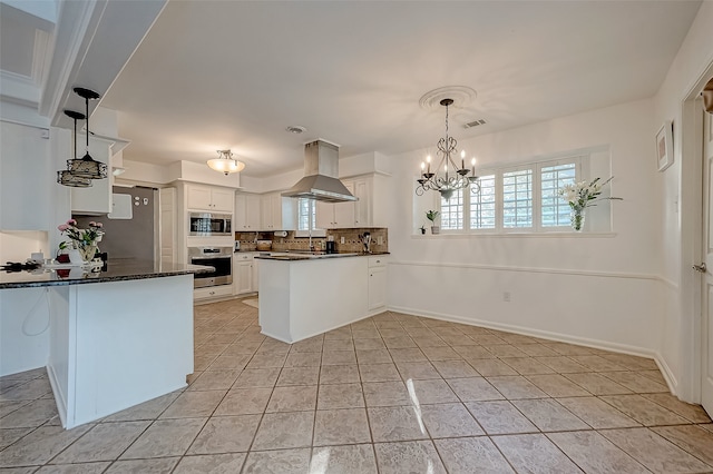 kitchen featuring ventilation hood, white cabinetry, kitchen peninsula, and appliances with stainless steel finishes