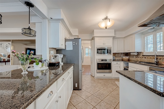 kitchen featuring white cabinets, decorative backsplash, pendant lighting, and stainless steel appliances