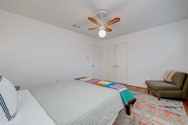 bedroom featuring hardwood / wood-style floors, ceiling fan, and a closet