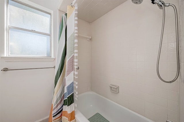 bathroom with shower / bath combo and a healthy amount of sunlight