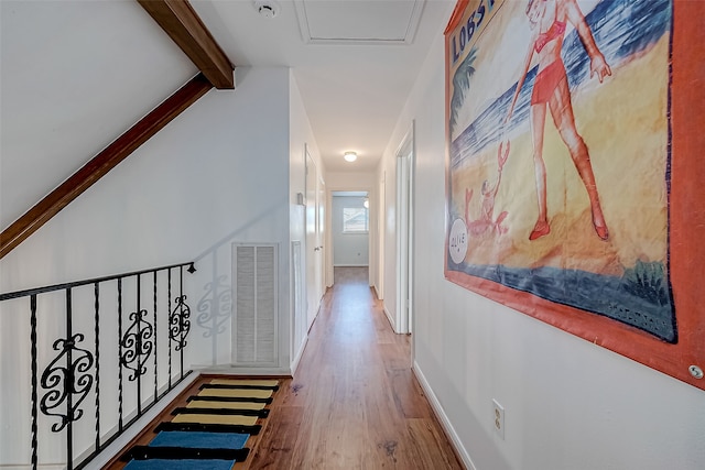 corridor with hardwood / wood-style floors and lofted ceiling with beams