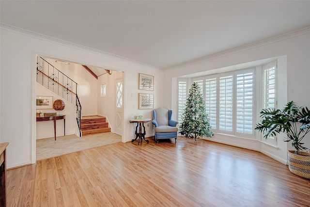 sitting room with wood-type flooring and crown molding