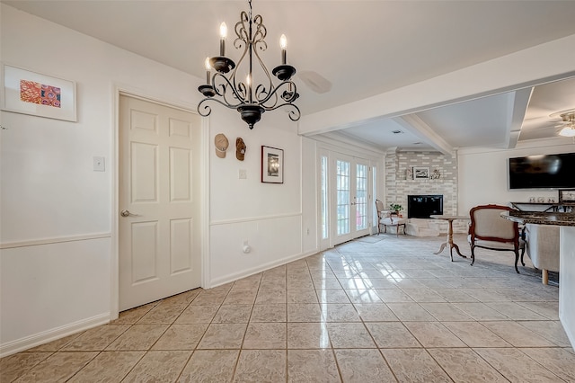 unfurnished dining area featuring french doors, a fireplace, light tile patterned floors, an inviting chandelier, and beamed ceiling