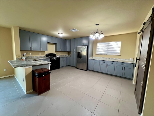 kitchen featuring sink, a barn door, black range with gas stovetop, stainless steel refrigerator with ice dispenser, and a notable chandelier