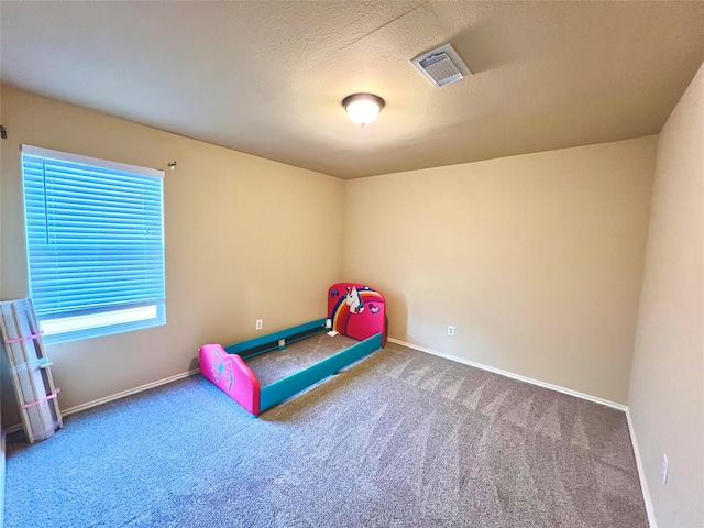 unfurnished bedroom featuring carpet flooring and a textured ceiling