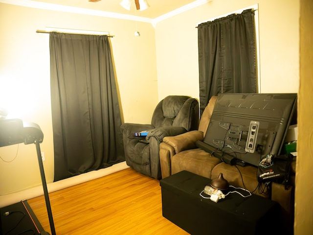 living area with ceiling fan, ornamental molding, and light wood-type flooring