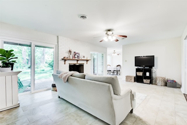 living room featuring a wealth of natural light, a fireplace, and ceiling fan