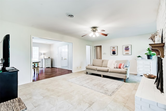 living room with a brick fireplace and ceiling fan