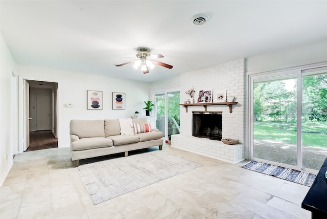 living room with ceiling fan, plenty of natural light, and a brick fireplace