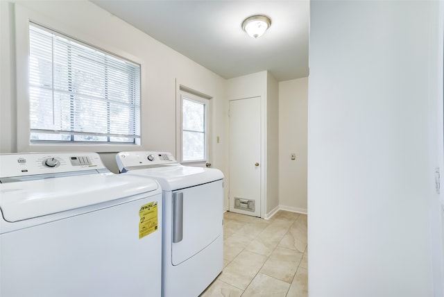 clothes washing area featuring separate washer and dryer and light tile patterned floors