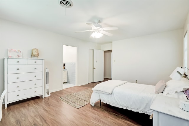 bedroom with connected bathroom, ceiling fan, and hardwood / wood-style floors