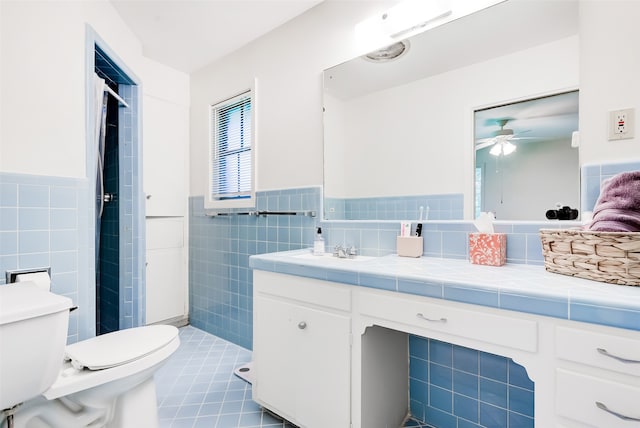 bathroom with vanity, tile patterned flooring, ceiling fan, toilet, and tile walls