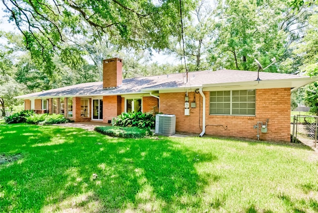 back of house featuring a lawn and central AC