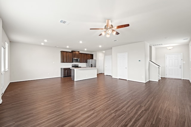 unfurnished living room with ceiling fan and dark wood-type flooring