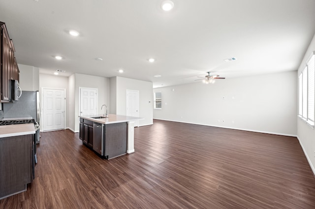 kitchen featuring dark brown cabinets, an island with sink, dark hardwood / wood-style floors, and sink