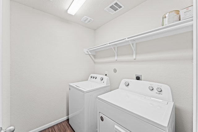 clothes washing area with independent washer and dryer and dark hardwood / wood-style flooring