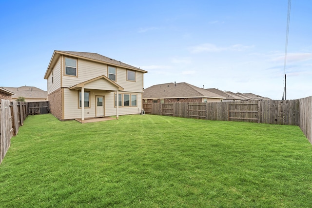 rear view of house featuring a yard