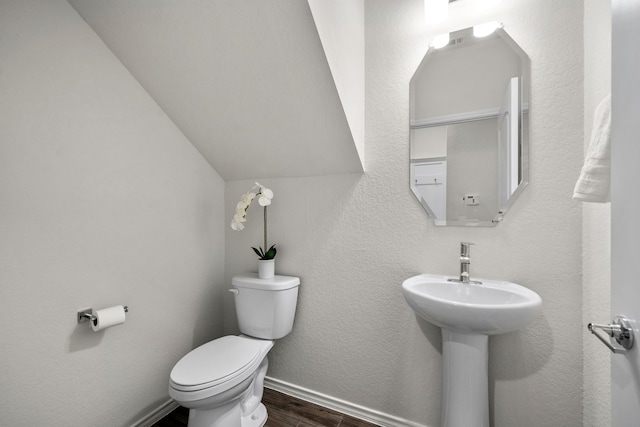 bathroom with hardwood / wood-style floors, toilet, and lofted ceiling