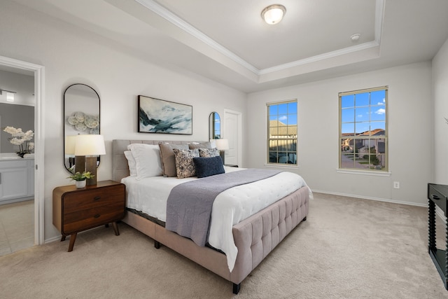 bedroom featuring crown molding, a raised ceiling, light carpet, and connected bathroom