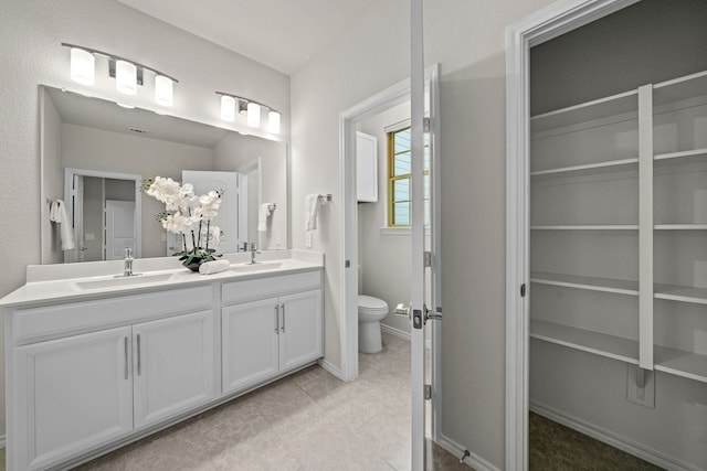 bathroom featuring tile patterned floors, vanity, and toilet