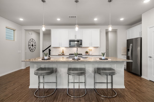 kitchen featuring white cabinetry, a kitchen island with sink, stainless steel appliances, and decorative light fixtures