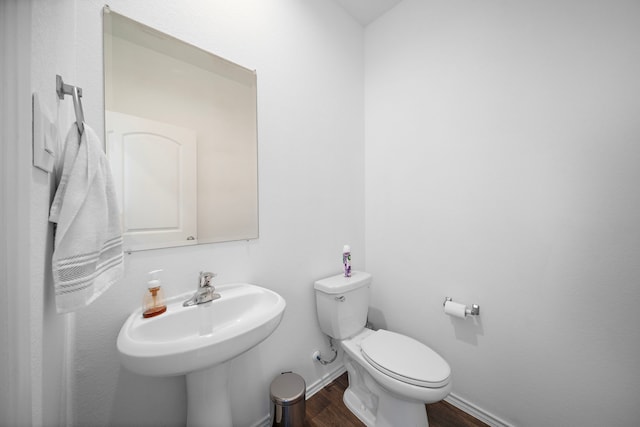 bathroom with sink, toilet, and hardwood / wood-style flooring