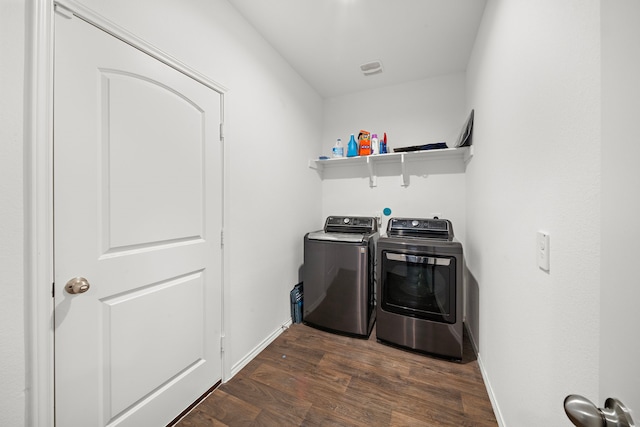 clothes washing area with separate washer and dryer and dark hardwood / wood-style flooring