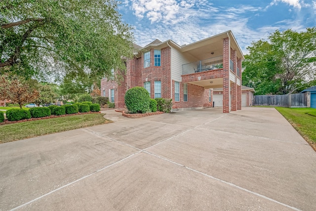 2519 Meadow Tree Ln, Spring, TX 77388 - view of front facade with a balcony, brick siding, concrete driveway, a garage, and a carport