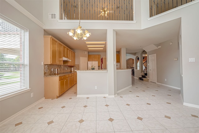 kitchen with a chandelier, backsplash, white fridge, and a wealth of natural light