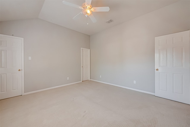 carpeted spare room with ceiling fan and vaulted ceiling