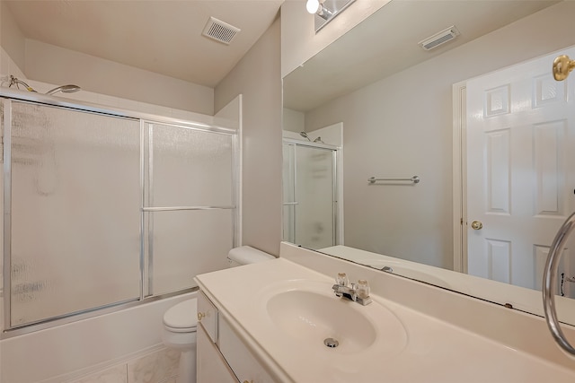 full bathroom with tile patterned floors, vanity, bath / shower combo with glass door, and toilet