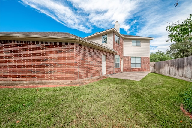 back of house featuring a lawn and a patio area