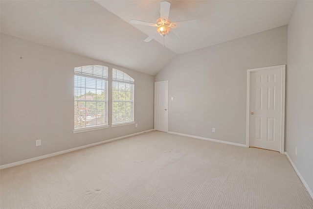 spare room with ceiling fan, light colored carpet, and vaulted ceiling