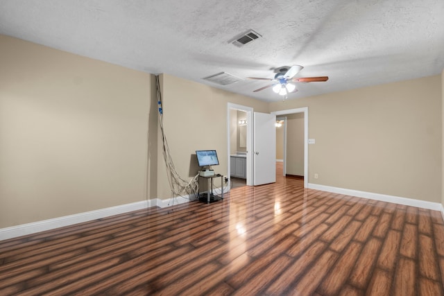 empty room with ceiling fan, dark hardwood / wood-style flooring, and a textured ceiling