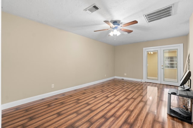 interior space with dark hardwood / wood-style floors, ceiling fan, a textured ceiling, and french doors