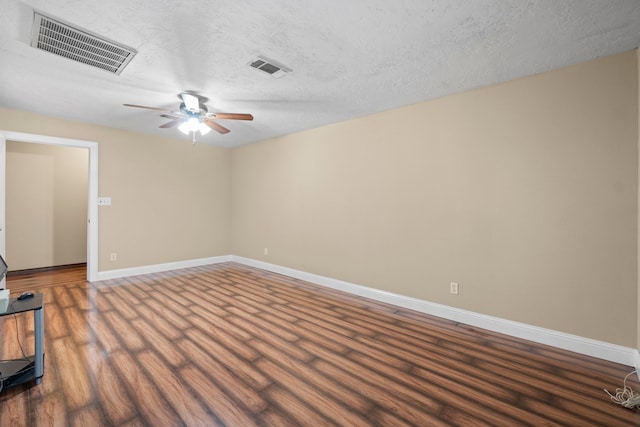 empty room featuring a textured ceiling, dark hardwood / wood-style floors, and ceiling fan