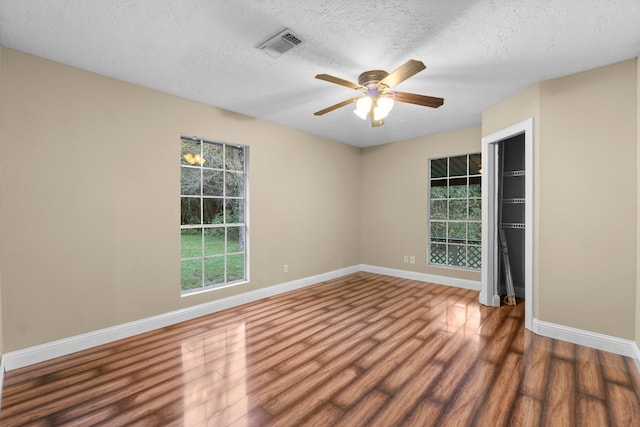 spare room featuring a textured ceiling, dark hardwood / wood-style flooring, and ceiling fan