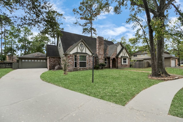 tudor house featuring a front yard and a garage